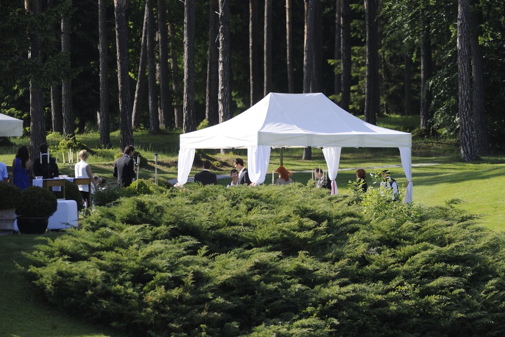 Poročni obred je potekal na prostem, pod belim šotorom.