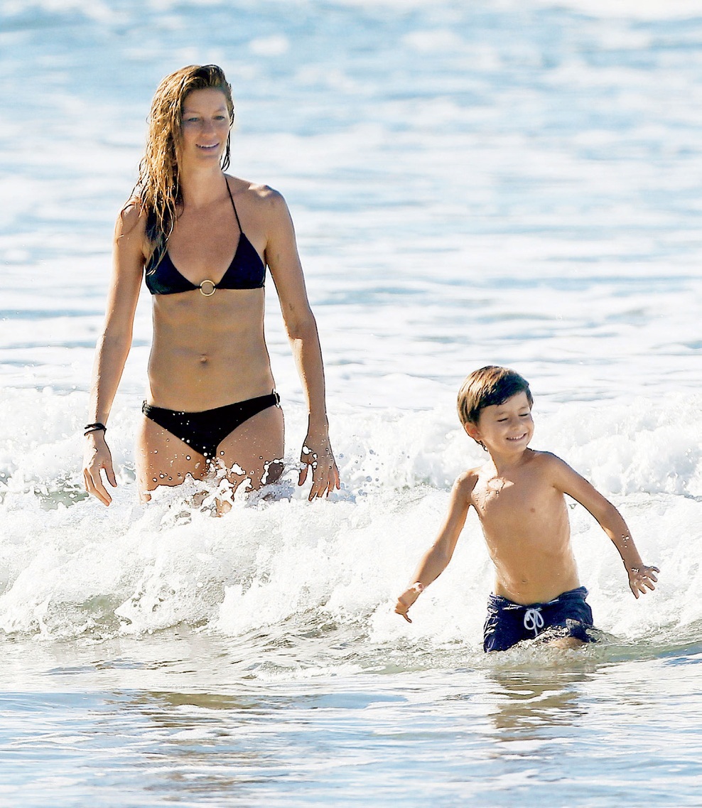 Gisele s hčerko Vivian in kužkoma uživa na plaži.