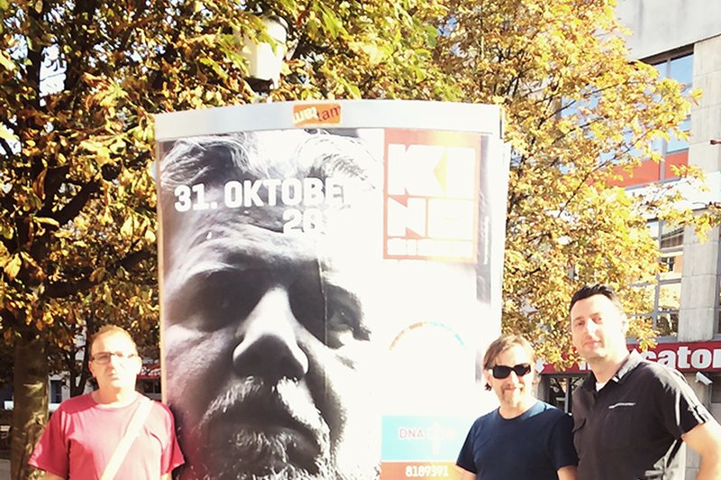 Obra, Tučo in Bošti iz Dan D so se v Novem mestu slikali pred plakatom, na katerem je njihov pevec Tokac (foto: osebni arhiv)