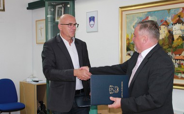 Viktor Dolinšek, direktor podjetja Komunalne gradnje Grosuplje, in Franc Škufca, župan občine, sta si segla v roke.