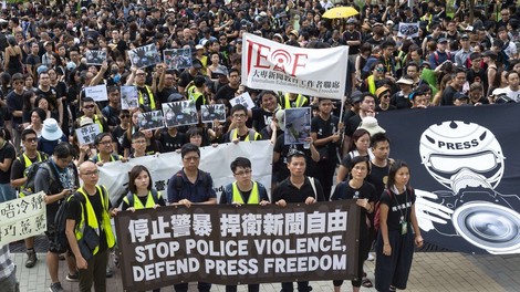 V Hongkongu moški v belih majicah in s palicami huje pretepli demonstrante