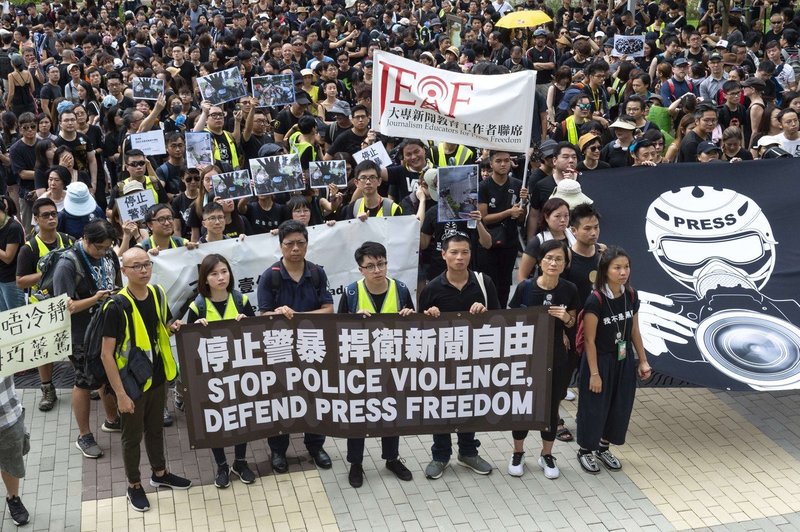 V Hongkongu moški v belih majicah in s palicami huje pretepli demonstrante (foto: profimedia)