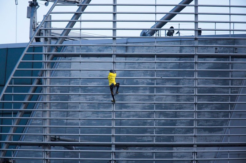 "Francoski spiderman" na stolpnico v Hongkongu splezal z zastavo miru (foto: Profimedia)