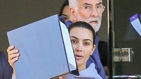 Kim Kardashian so paparaci ujeli povsem brez ličil, ko je hitela v avto in se skrivala za mapo