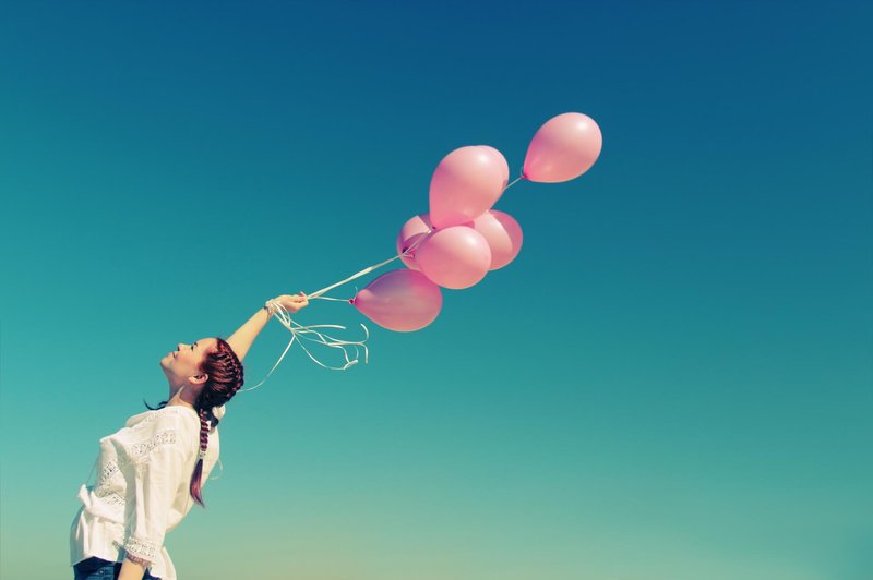 Young redhead woman holding pink balloons (foto: Foto: Shutterstock Shutterstock)