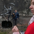 Banksy potrdil, da je umetniška kreacija na zbombardirani stavbi v Ukrajini njegova