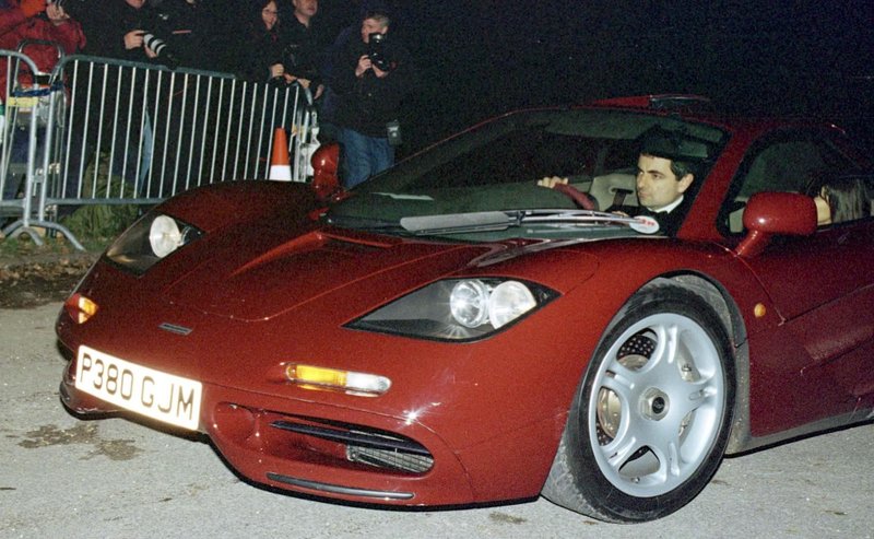 Rowan Atkinson se pelje na praznovanje 50. rojstnega dne takrat še princa Charlesa. Peljal je svoj McLaren F1.
