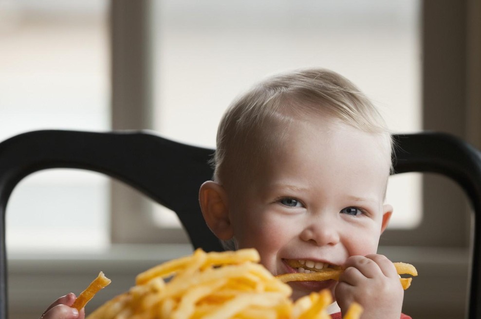 Otrok uživa v pomfriju (foto: Profimedia)